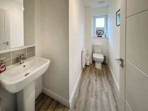 Ein Badezimmer mit Waschbecken, Toilette und einem Fenster mit Blick.