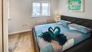 A bedroom with a bed, a window, a radiator, a lamp, and a painting on the wall. - 3 bedroom accommodation in Inverness (Inverness)