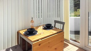 A small wooden table with black plates, a wine glass, and a bottle of wine. - 2 bedroom accommodation in Bude (Bude)