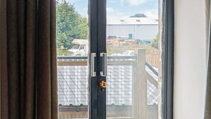 A view from a balcony with a metal railing, a glass door with a lock, and a clear sky. - The Old Mill Apartment - UK48028 (Tain)