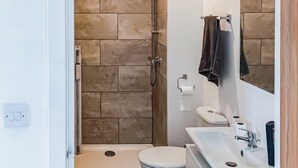 A bathroom with a shower, toilet, and sink. - The Old Mill Apartment - UK48028 (Tain)