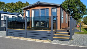 A modern building with large windows, a wooden facade, and a set of stairs leading to the entrance. - 2 bedroom accommodation in Carnaby, near Bridlington (Carnaby, near Bridlington)