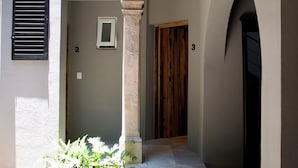 A hallway with a column, a door marked with the number 3, and a door marked with the number 2. - CASA XANTHE (San Miguel de Allende)