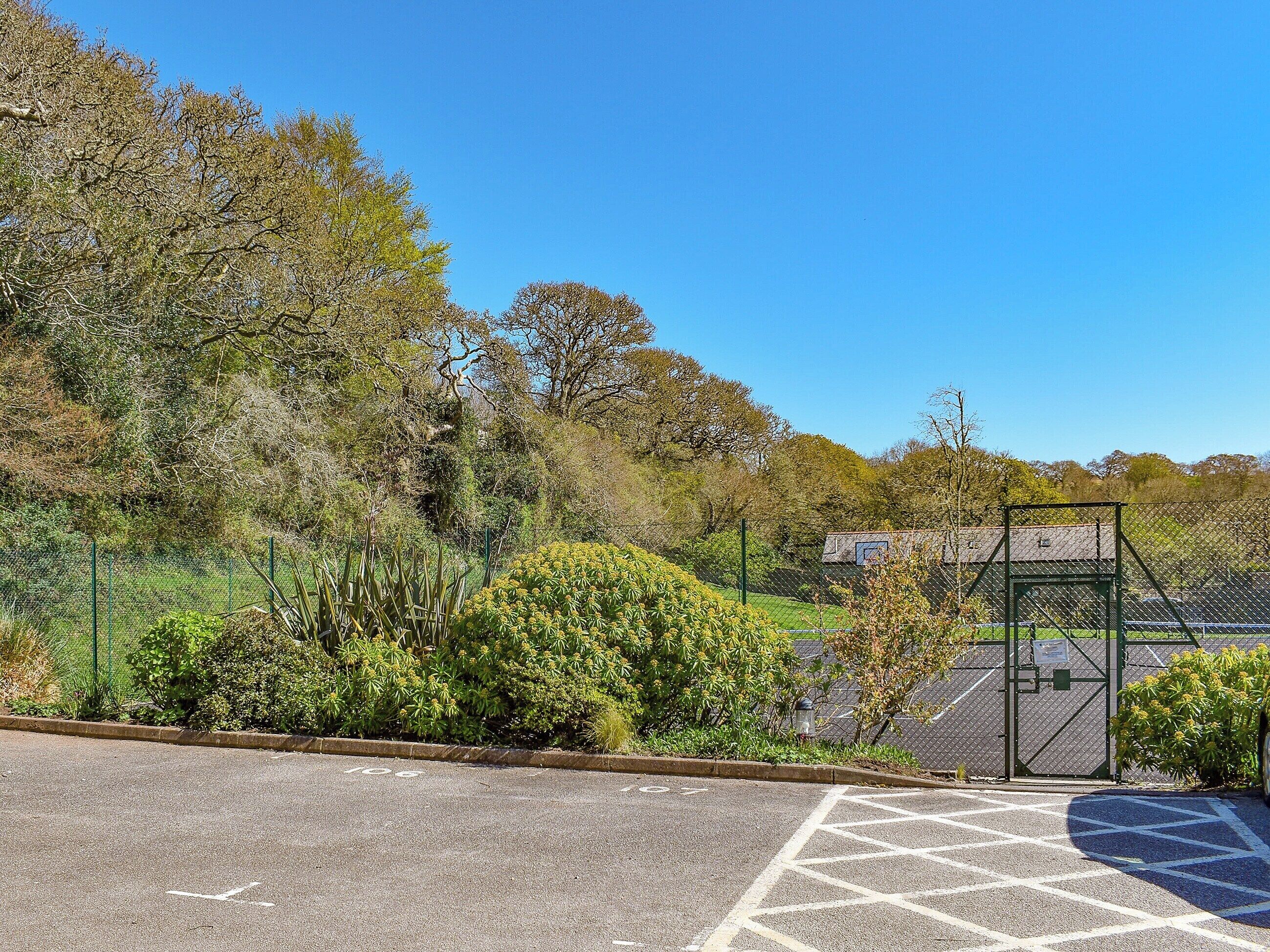 A parking area with marked spaces and a gated entrance.