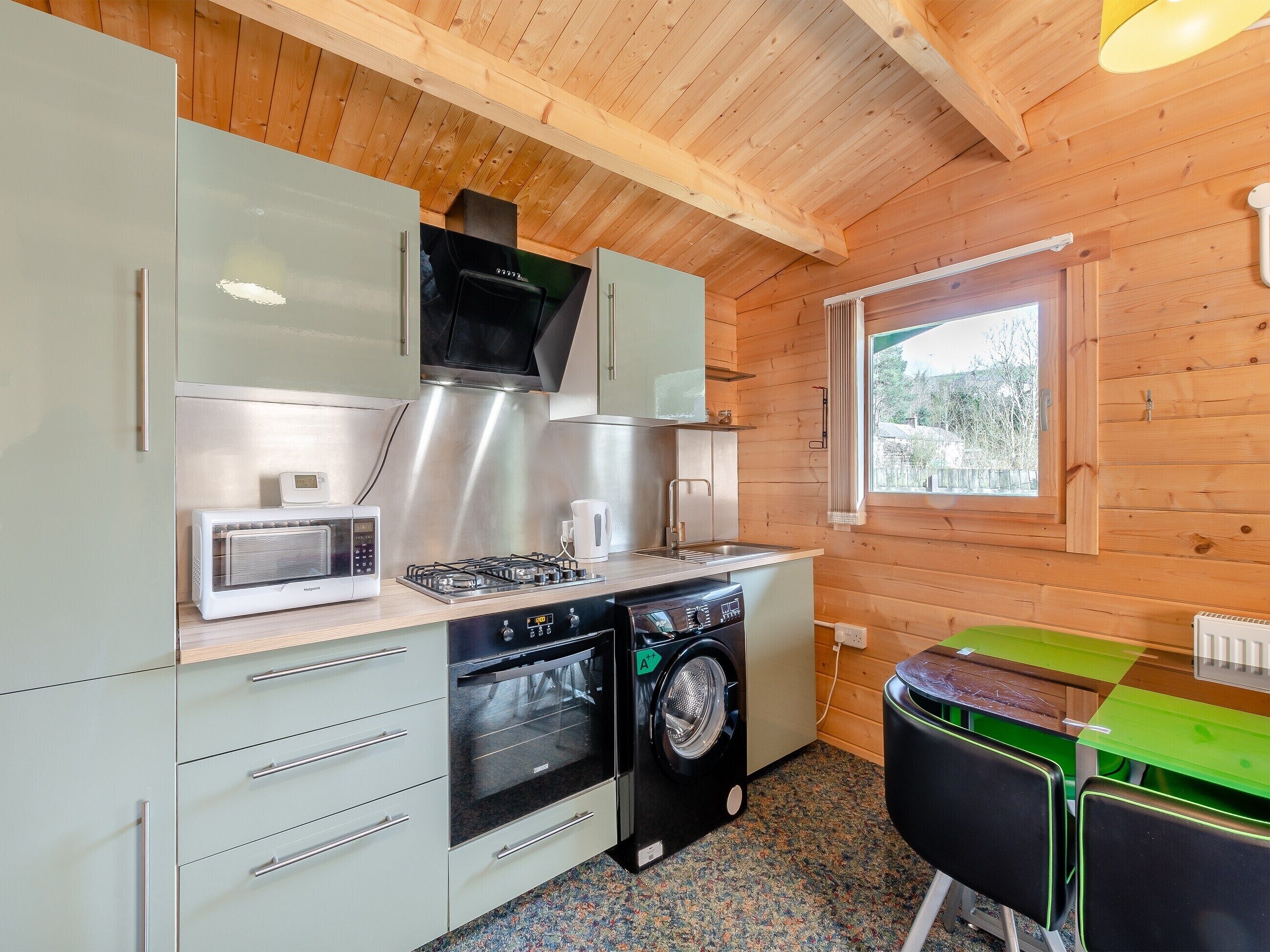 Una cocina compacta equipada con microondas, estufa, horno y lavadora.