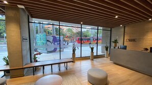 Un espace d’accueil moderne avec un plafond en bois, de grandes fenêtres et un comptoir d’accueil.