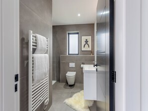 A modern bathroom with a toilet, sink, and towel rack. - Lligwy Lodge 3 - UK42793 (Llangefni)