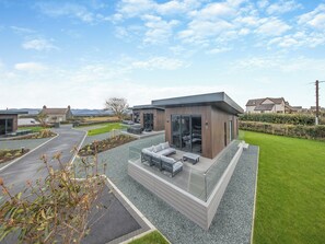 A modern house with a patio, a garage, and a well-maintained lawn. - Lligwy Lodge 3 - UK42793 (Llangefni)
