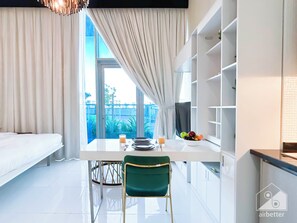 Enjoy a comfortable living area with a large window, dining table, and shelving unit.
