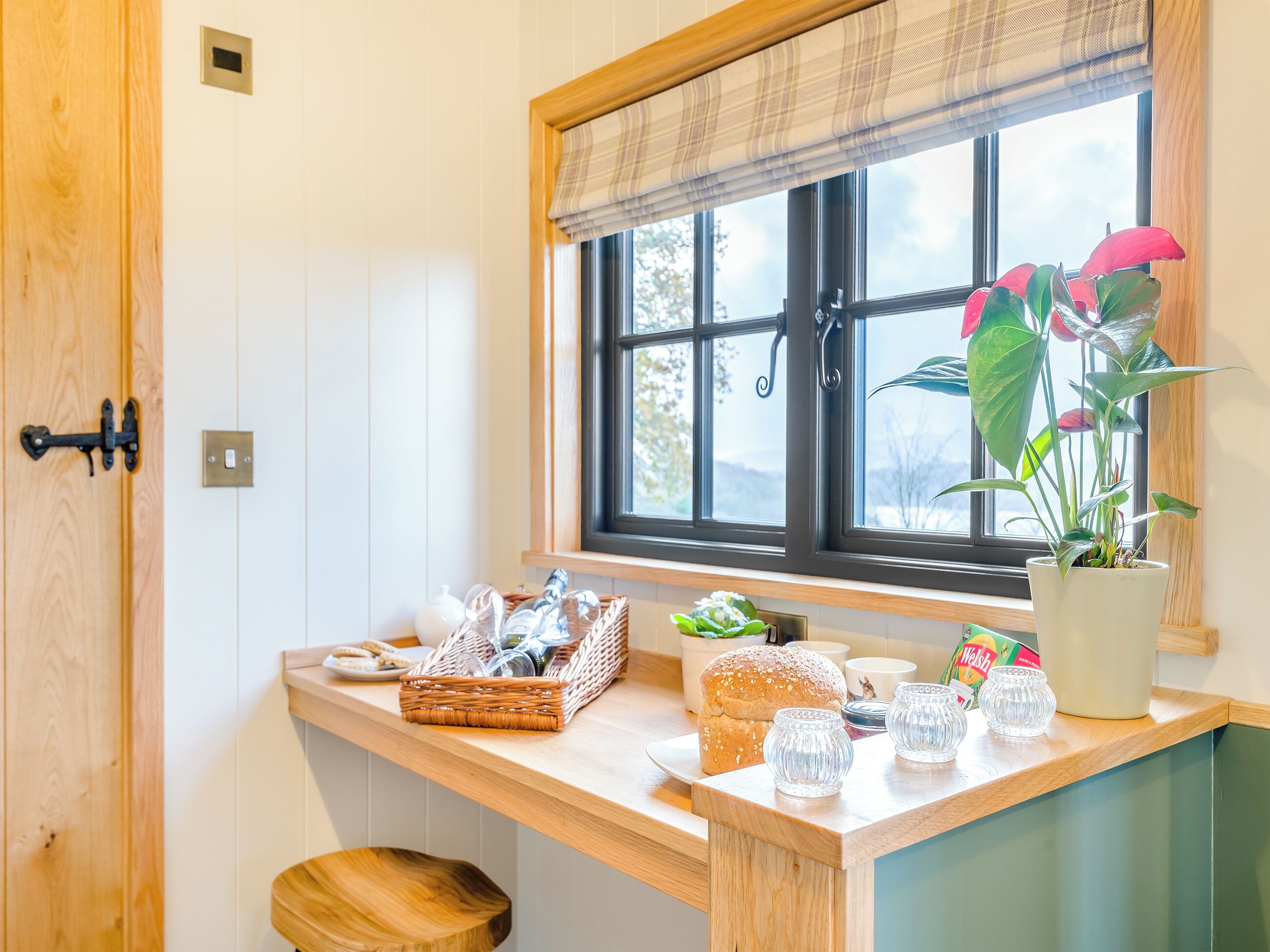 A kitchen counter with a basket, bread, and glassware.
