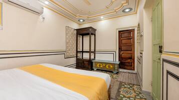 Un dormitorio con una cama, un armario de madera, una puerta verde y un suelo estampado.