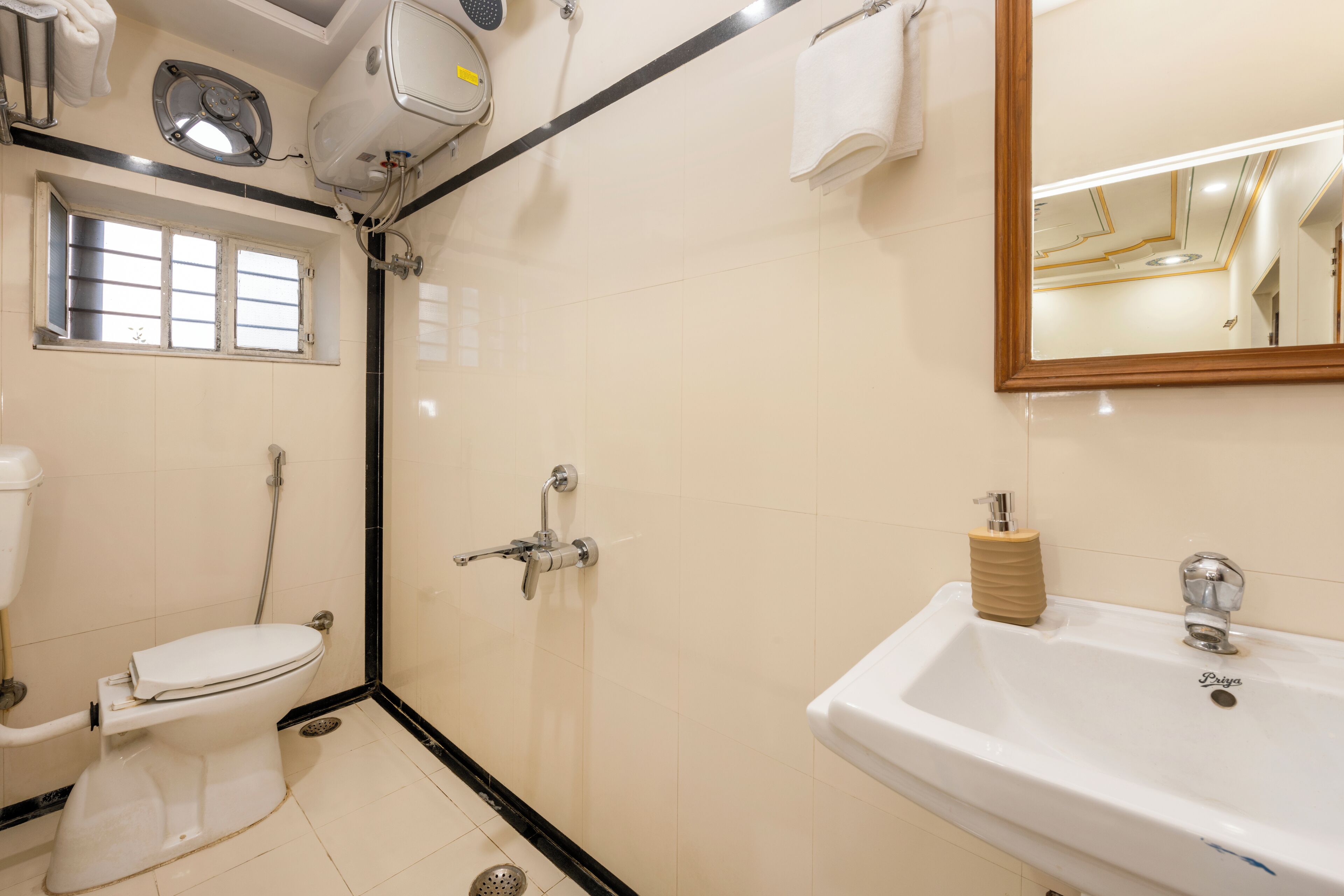 A bathroom with a toilet, shower, sink, and mirror.