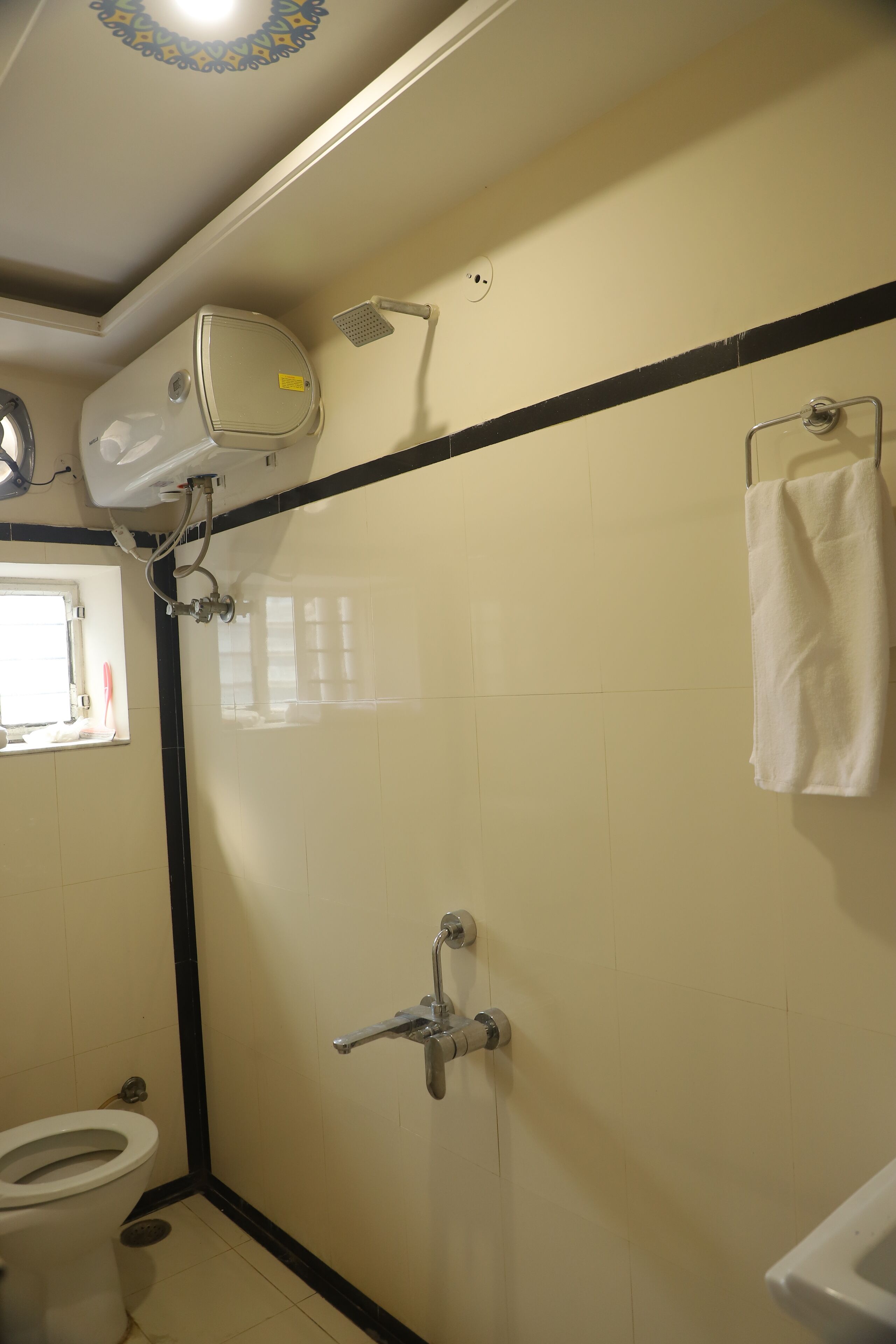 A bathroom with a toilet, a shower, and a sink.