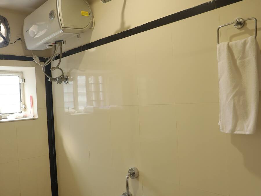 A bathroom with a toilet, a shower, and a sink.