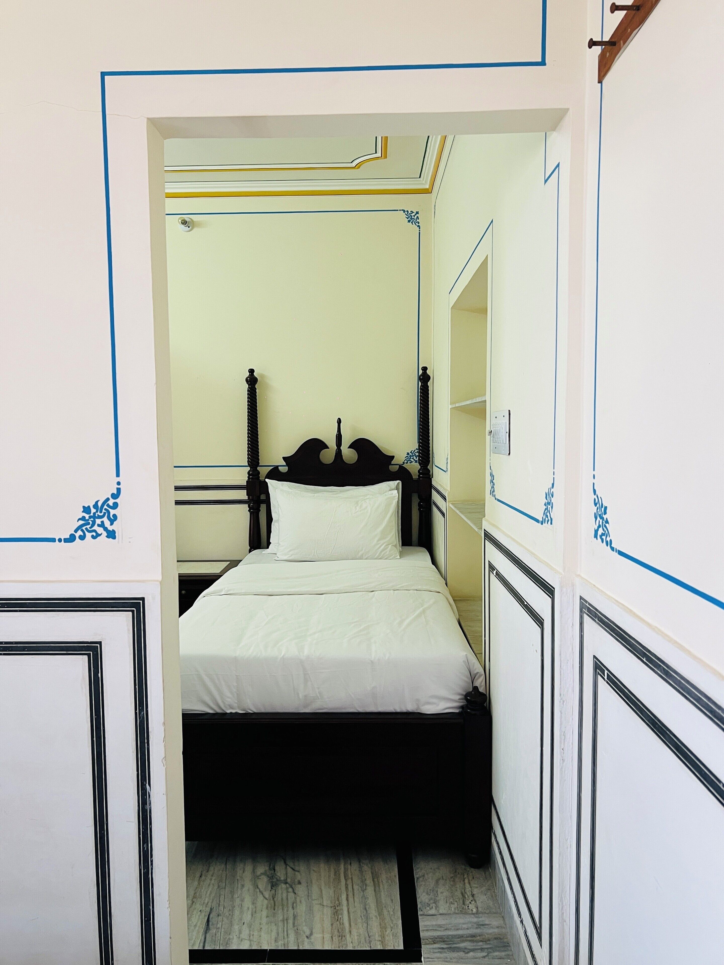 Un dormitorio ordenado con cama, espejo y puerta.