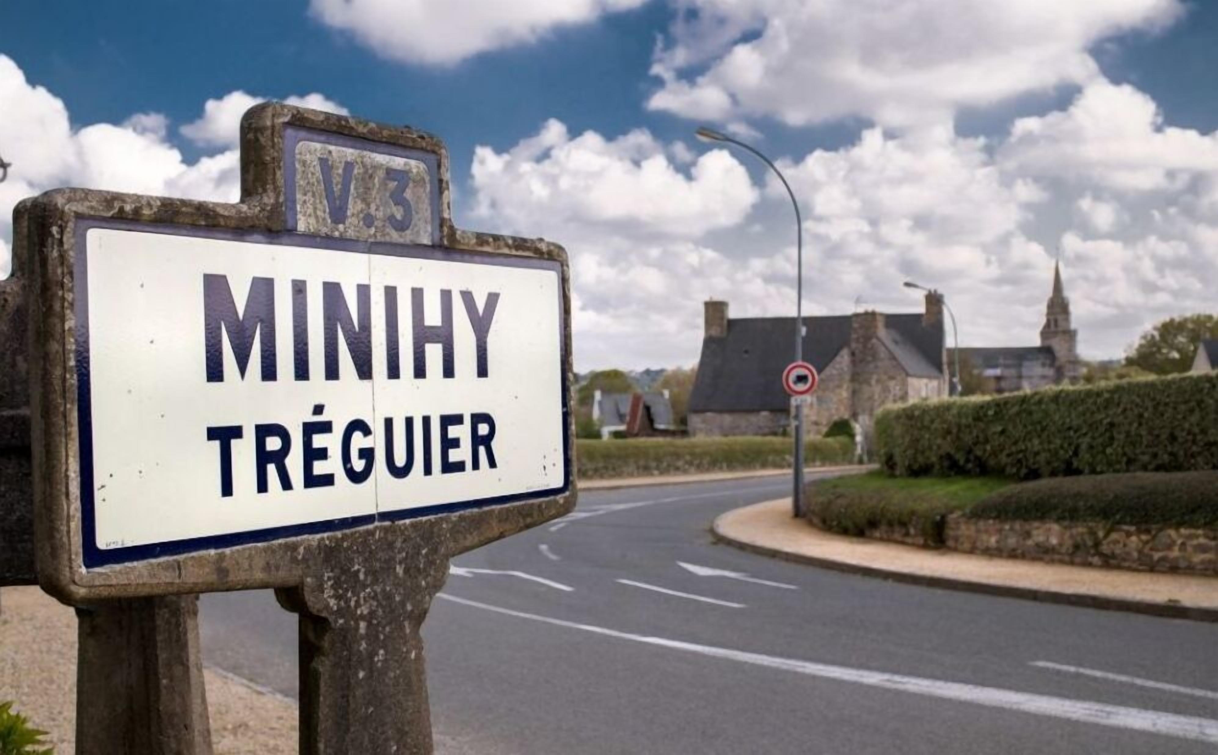 Een straatbordje voor 'MINIHY TRÉGUIER', met een heldere weg en een verboden toegangsbordje op de achtergrond.