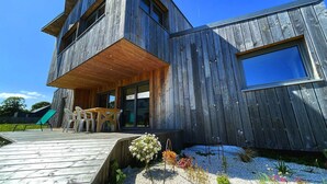 A modern wooden house with a covered patio and outdoor seating. - house Porzh Loaz. (Plouha)