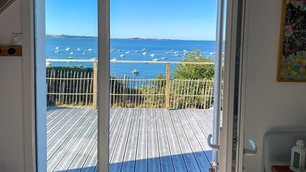 A wooden deck with a view of the sea and boats. - Ty Lazo: Serenity by the sea, haven of peace. (Plouézec)