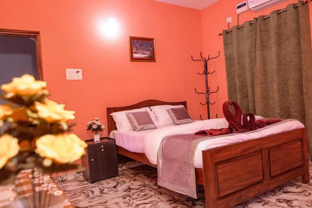 Un dormitorio con cama de madera, una mesita de noche, un perchero en la pared y un cuadro enmarcado.
