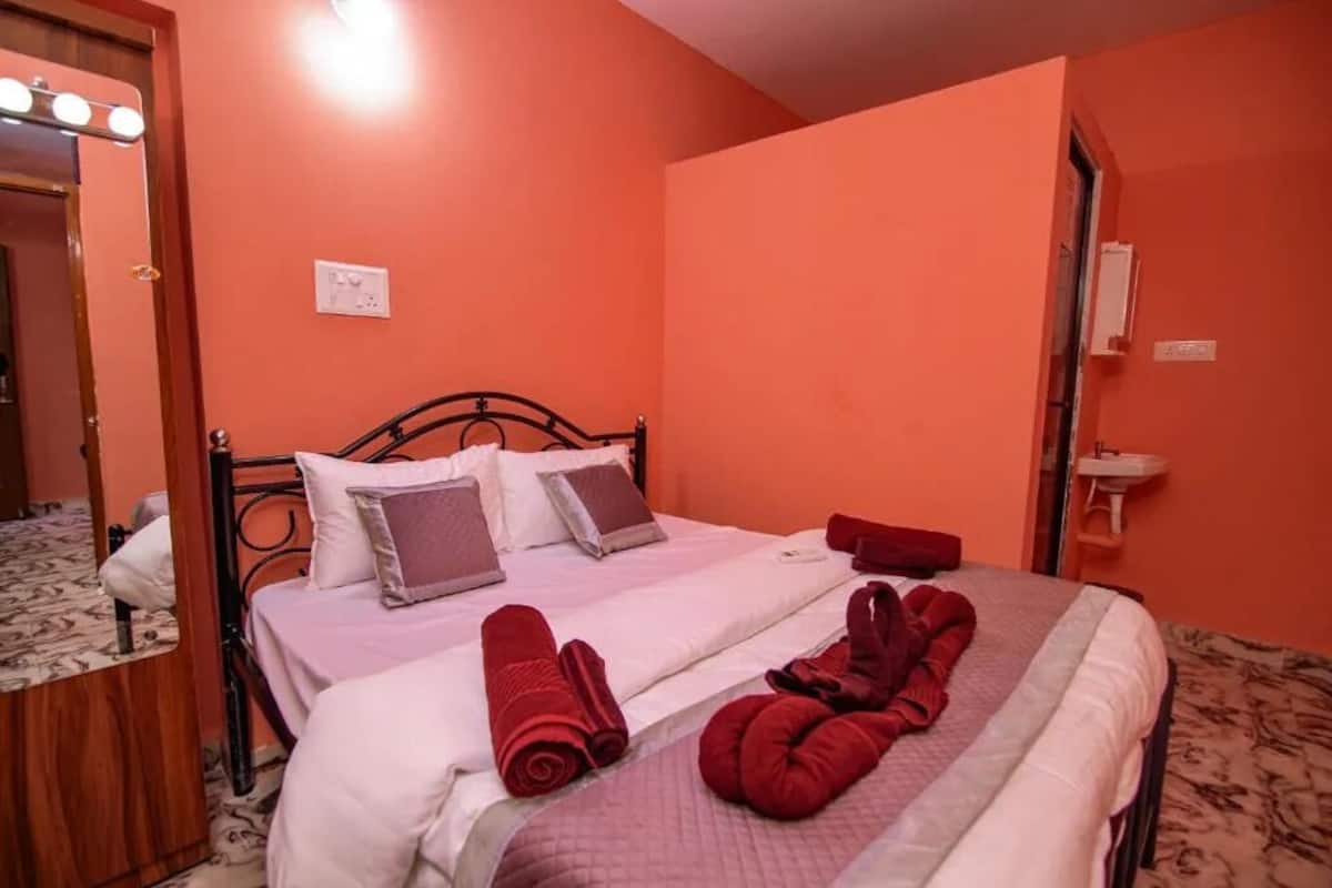 Une chambre d’hôtel avec un lit, un miroir avec éclairage intégré et un lavabo.