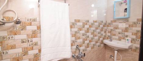 A bathroom with a tiled floor, a white sink, a mirror, and a towel rack.