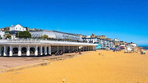 A coastal hotel with a large balcony, multiple stories, and a sandy beach in the foreground. - Cute Cosy Cottage | Ramsgate Historic Area | 2bd (Kent)