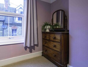 A room with a window, a wooden dresser, and a mirror. - Cute Cosy Cottage | Ramsgate Historic Area | 2bd (Kent)