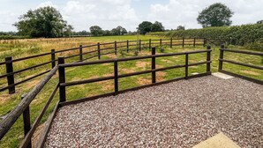 A gravel pathway with wooden railings leading to a grassy field. - 1 bedroom accommodation in Berrow, near Malvern (Berrow, near Malvern)