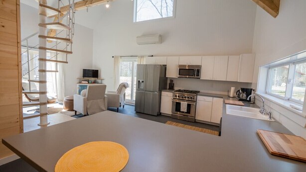 Una cocina moderna con una isla central, electrodomésticos integrados y un amplio ventanal.