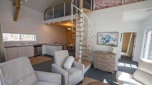 Un interior moderno con una escalera en espiral, un comedor y una cocina.