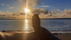 A silhouette of a person with their hand raised against a sunset over water. - House on the Island of Itaparica Bahia, with swimming pool and complete gourmet space (VERA CRUZ)