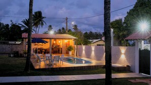 A backyard with a swimming pool, outdoor seating, and a patio area. - House on the Island of Itaparica Bahia, with swimming pool and complete gourmet space (VERA CRUZ)