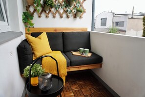 A balcony with a wooden bench, a small table with a plant, and a wall-mounted plant rack. - Chez Marie - cozy apartment in a quiet, central location in Bochum (Bochum)