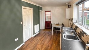A kitchen with a dining table and chairs, a window with a view, and a sink area. - 2 bedroom accommodation in Lincoln (Lincoln)