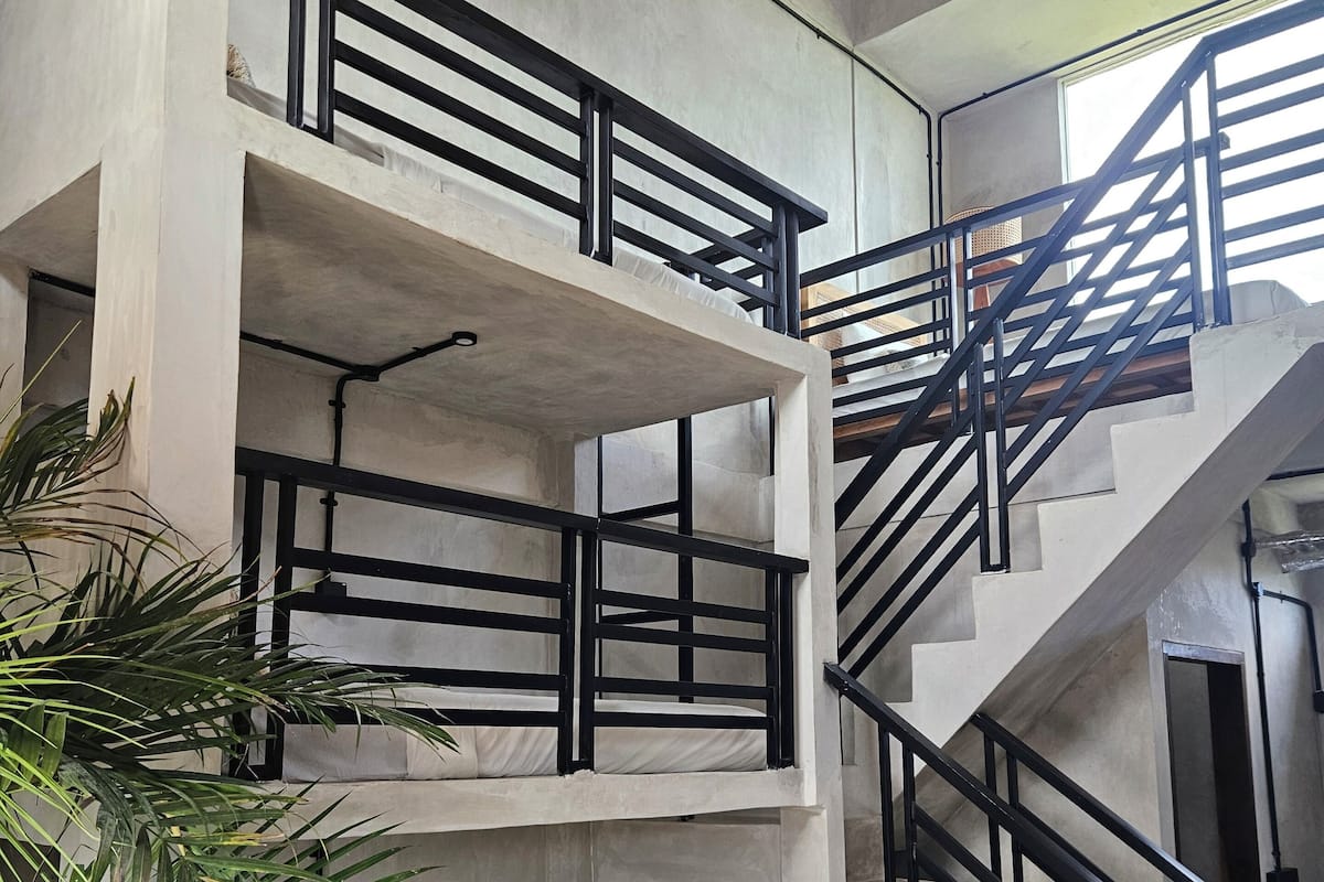 Una escalera de varios niveles con barandillas negras y estructura de hormigón.