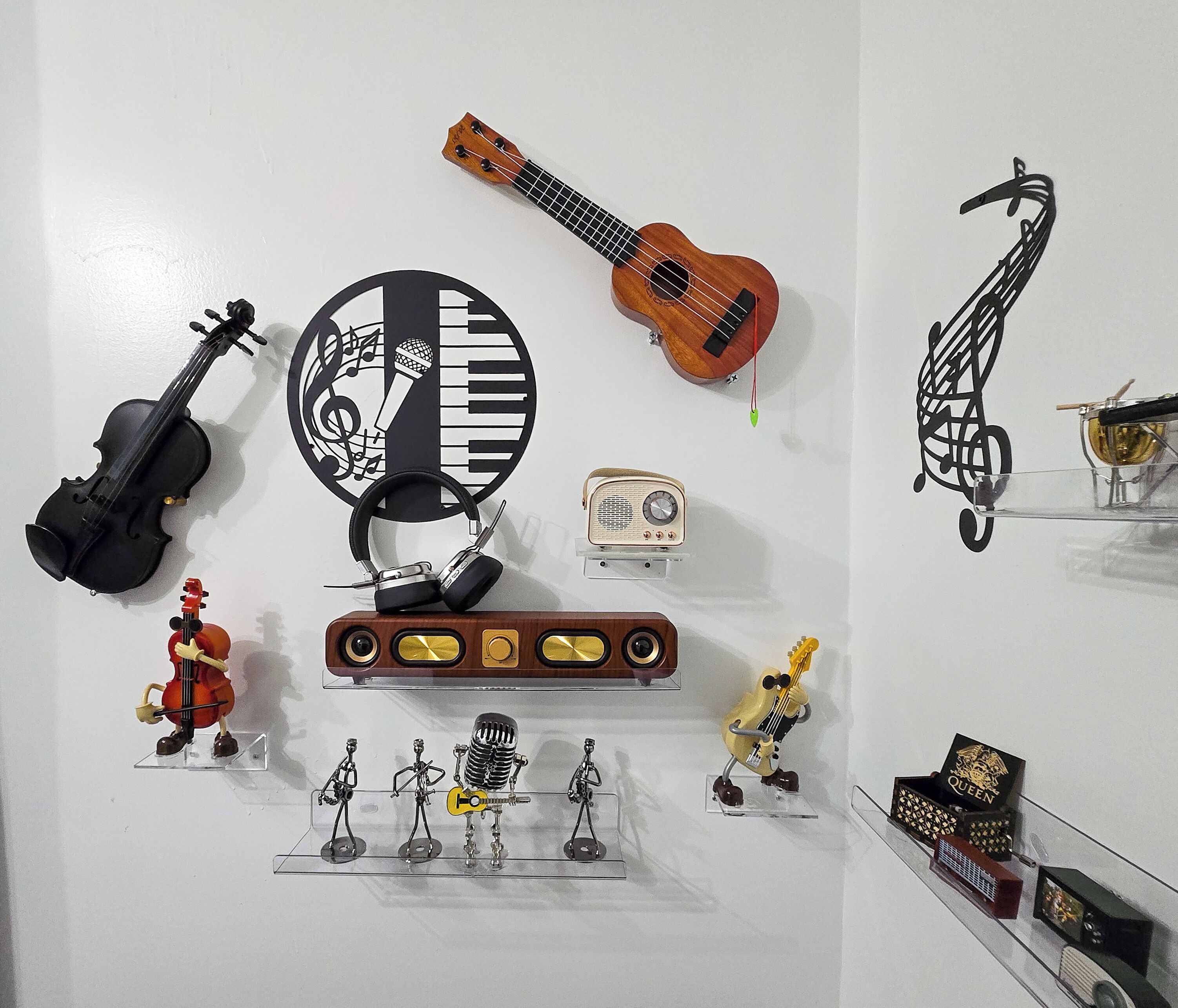 Een muur met verschillende muziekinstrumenten en beeldjes, waaronder een viool, ukelele en een skelet dat gitaar speelt.