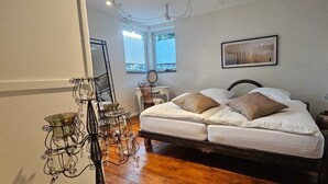 Un dormitorio con cama, mesita de noche, lámpara y ventana con persianas.