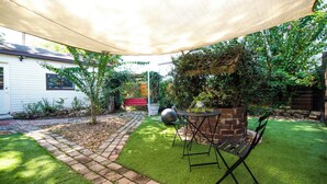 A backyard with a patio area, a brick wall, and a red bench. - Private Studio Suite (Lakeland)