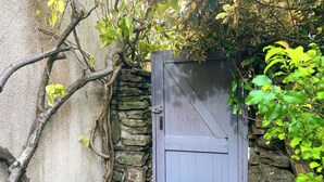 A stone wall with a wooden gate, surrounded by greenery. - 2 bedroom accommodation in Taff&rsquo;s Well, near Cardiff (Taff&rsquo;s Well, near Cardiff)
