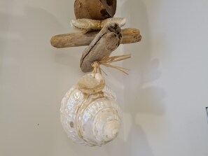 Een decoratieve compositie met een vogel, houten stokjes en een schelp.