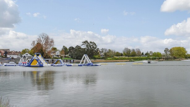 A calm lake with inflatable play structures and a dock.