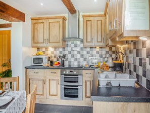 A modern kitchen with wooden cabinets, a microwave, a toaster, and a sink.