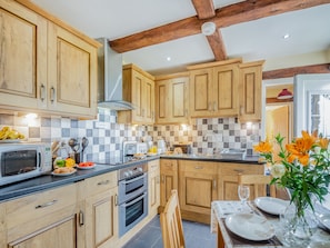 A kitchen with wooden cabinets, a microwave, a toaster, and a sink.