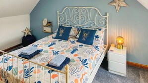 Een netjes opgemaakt bed met een bloemenprint, een decoratieve ster aan de muur en een bedlampje.