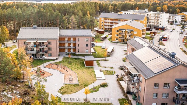 A multi-story hotel with a central courtyard, surrounded by trees and a view of a lake. - Cozy Haven Minutes From Central (Stockholms län)