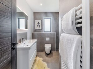 A modern bathroom with a white sink, toilet, and towel rack. - Cybi Lodge 6 - UK42798 (Llangefni)