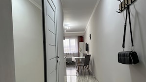 A hallway with a dining area, a coat rack, and a bench.