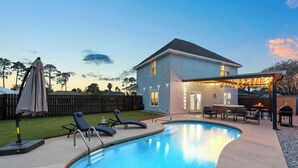 A backyard with a swimming pool, lounge chairs, a barbecue area, and a covered patio. - PCB Paradise Sands Oasis - Private Pool, Game Room, Hot Tub! (Panama City Beach)