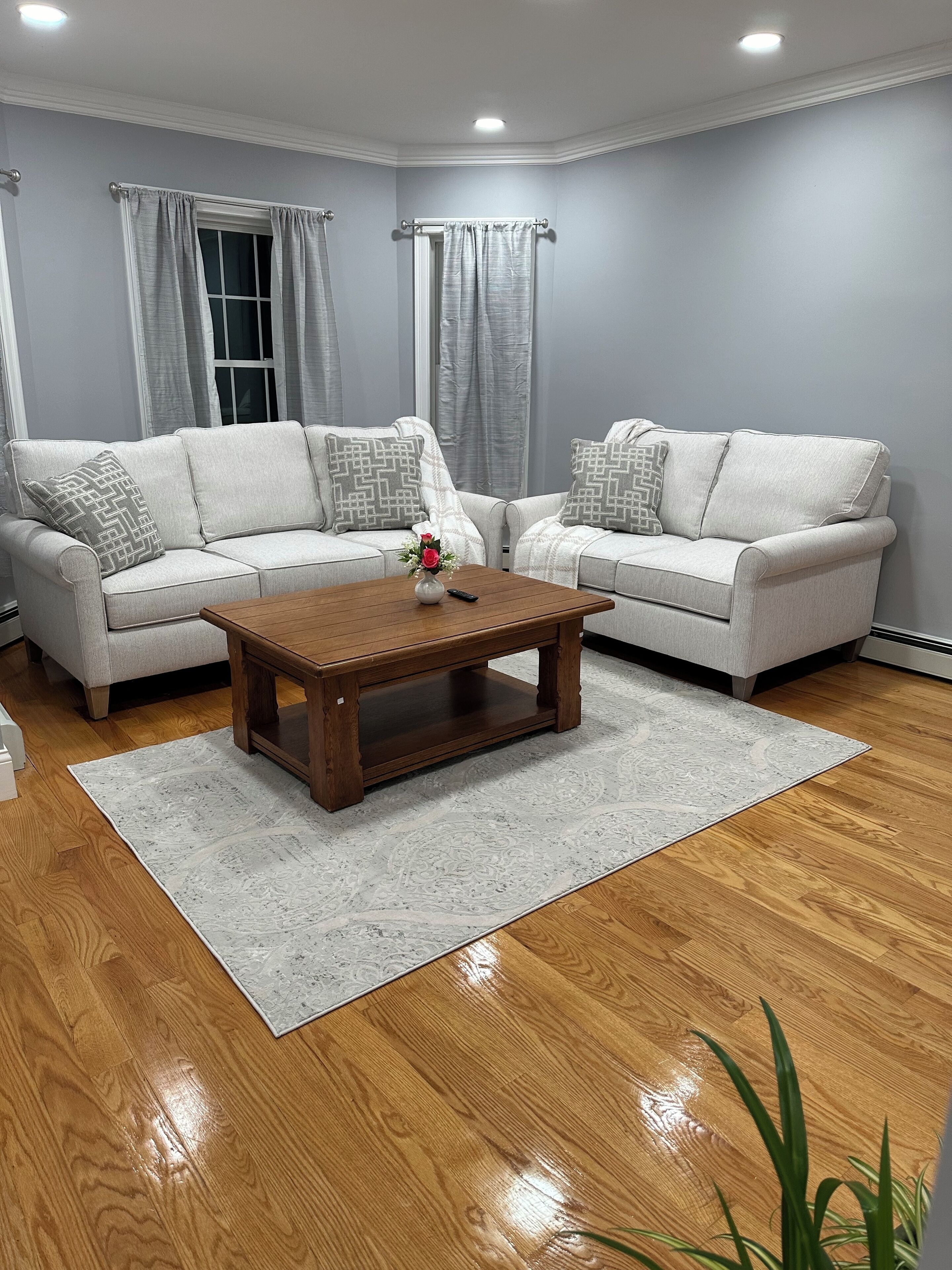 Ein Wohnzimmer mit zwei Sofas, einem Couchtisch und einem Teppich.