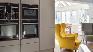 A modern kitchen with built-in appliances and a bright, open layout. - Pines Cottage - UK42110 (St. Margaret&rsquo;s Bay)